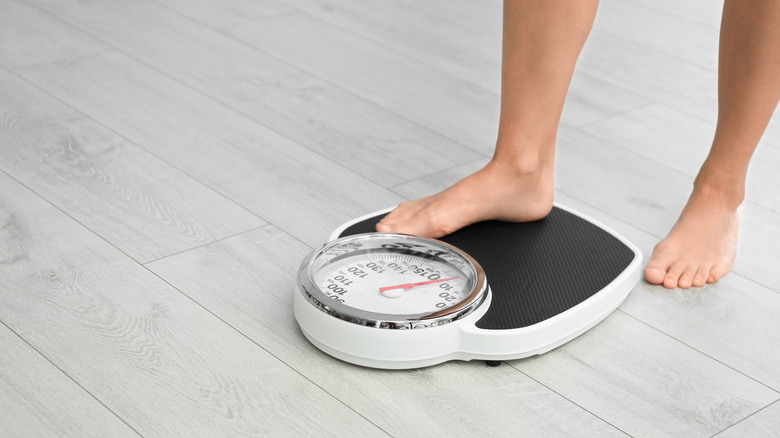 A woman's feet stepping onto a scale