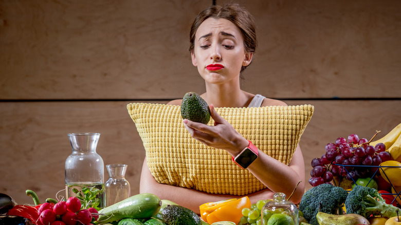 depressed woman holding an avocado